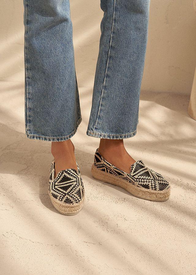 Gambe di donna con espadrillas estive alla moda e jeans brillanti