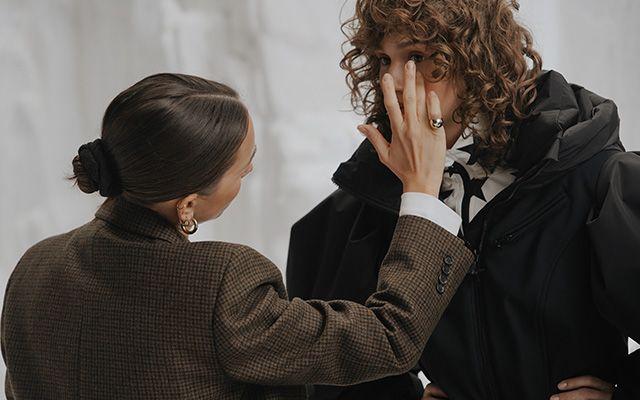 Femme améliorant le maquillage d'un homme pour une vidéo