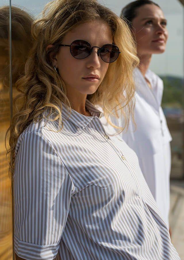 femme en chemise bleue rayée et lunettes de soleil