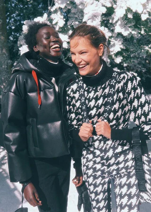 Two women laughing in fashionable outfits for the slopes