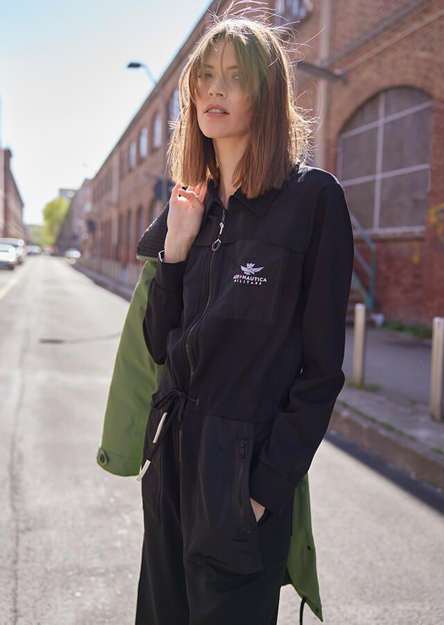 Stehende Frau in schwarzem Sweatshirt im Stil der 90er Jahre