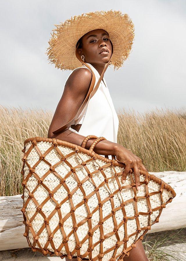 woman wearing a straw hat and carrying a braided handbag