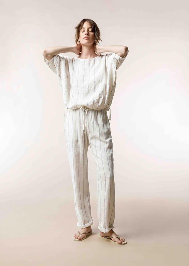 femme en pull blanc et pantalon beige