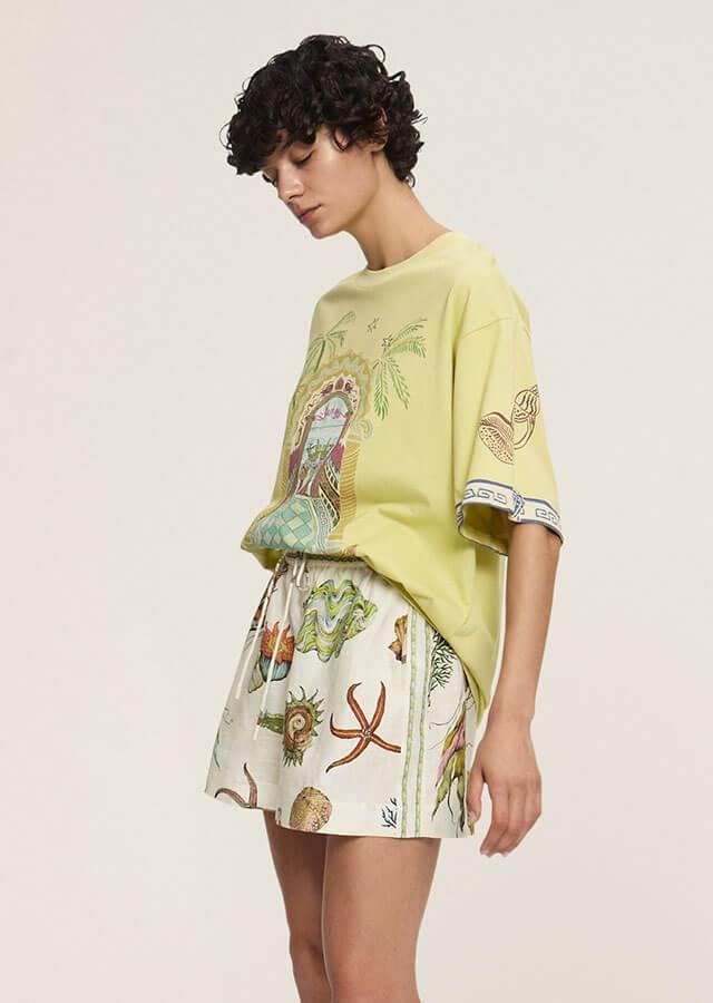 Kobieta w bluzce w wakacyjne motywy w modnym odcieniu 2025 butter yellow  