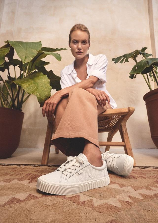Kobieta w białych, skórzanych sneakersach   