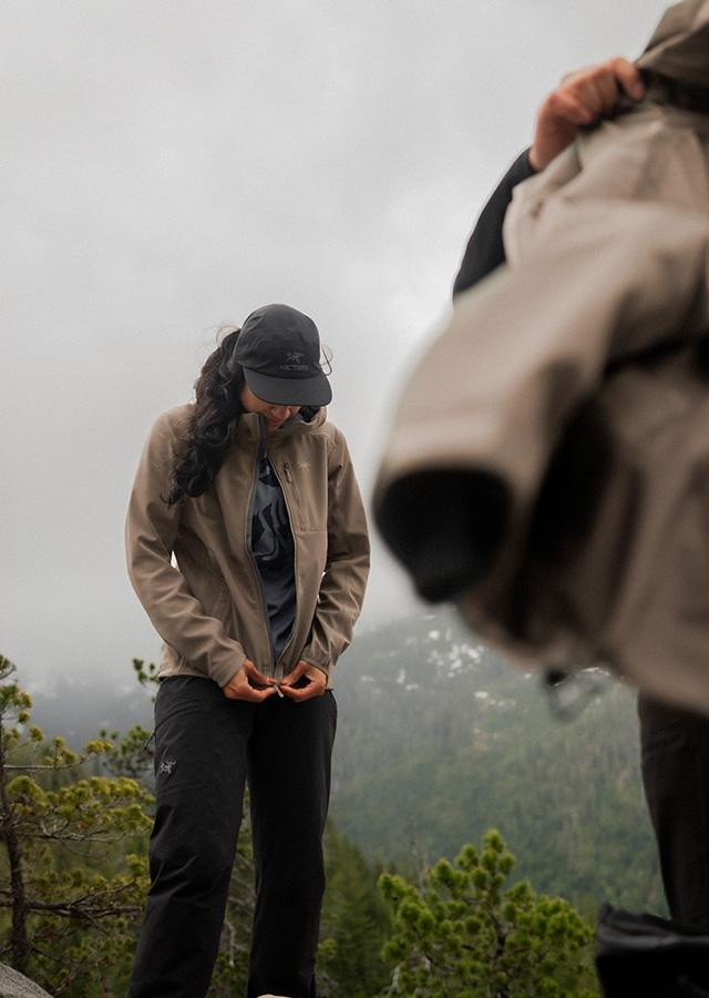 Kobieta podczas trekkingu w górach w beżowej kurtce z membraną Gore-Tex