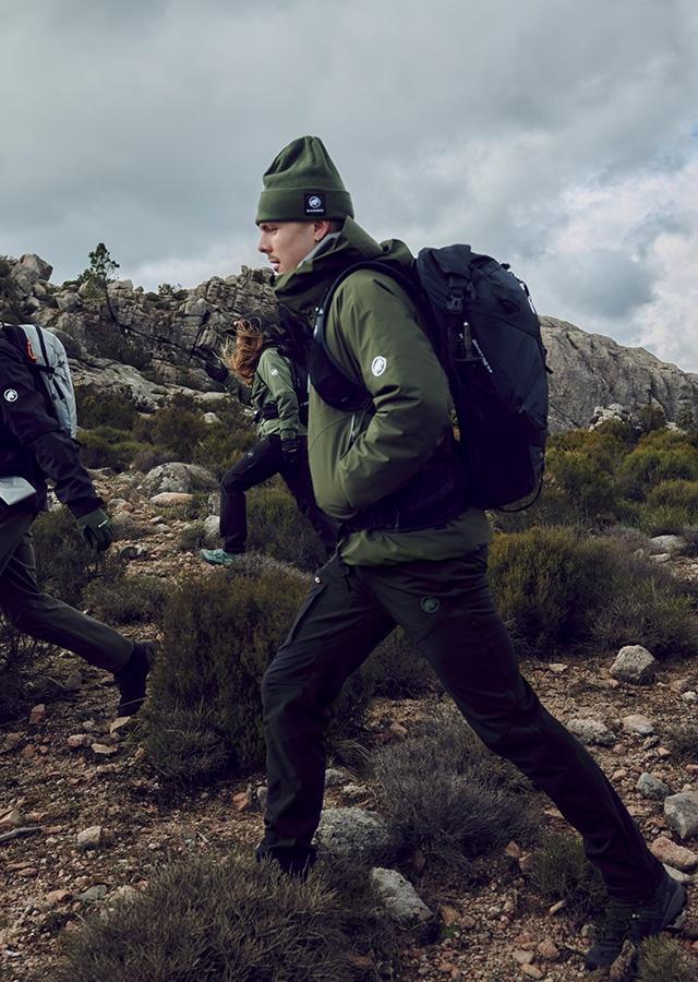 Mężczyzna w zielonej kurtce podczas trekkingu w górach