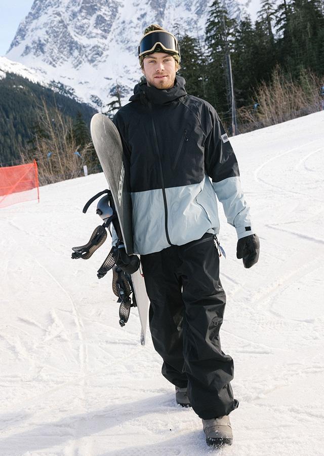 Mężczyzna w spodniach i kurtce snowboardowej na stoku 