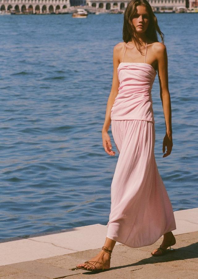 Kobieta w pudrowo-różowej zwiewnej sukience 
