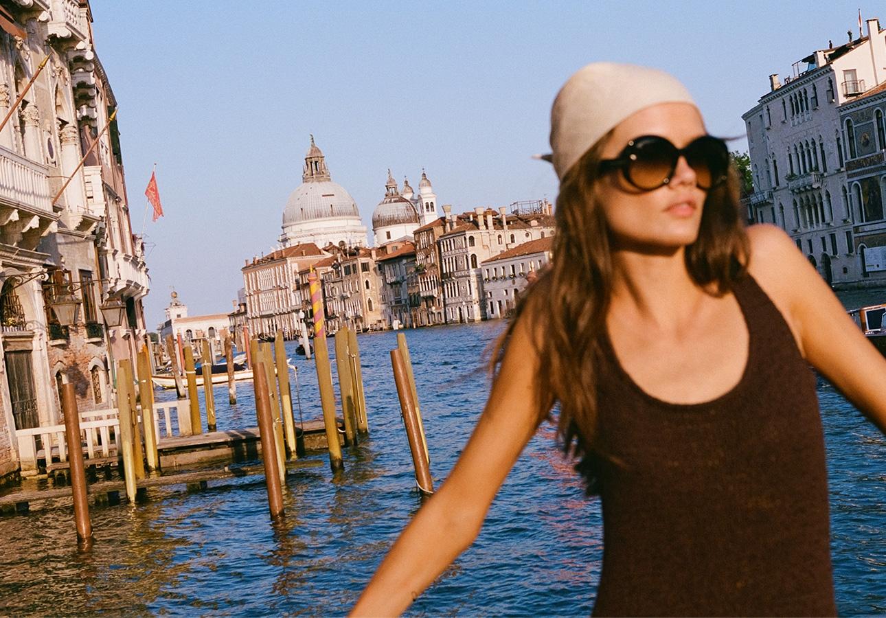 Kobieta w okularach przeciwsłonecznych i czarnym topie podczas city breaku   