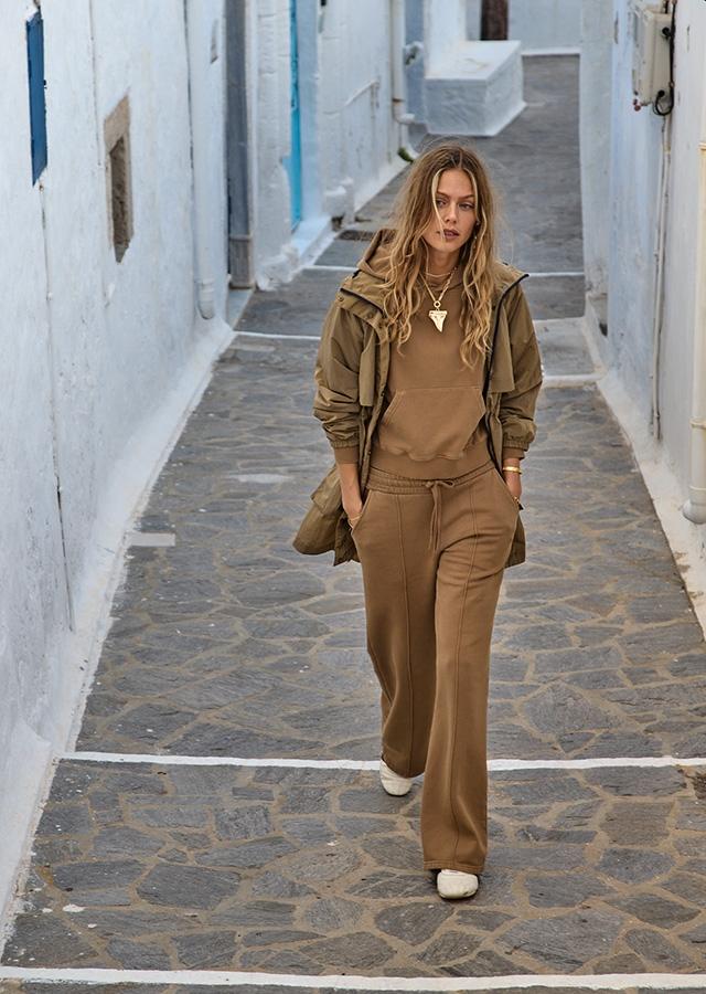 Jak ubrać się na city break? Kobieta w brązowym komplecie dresowym   