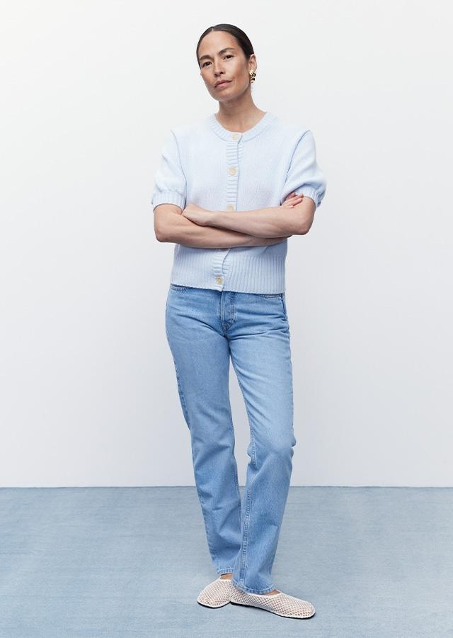 Kobieta w stylizacji old money – jasnych jeansach i kaszmirowym błękitnym swetrze