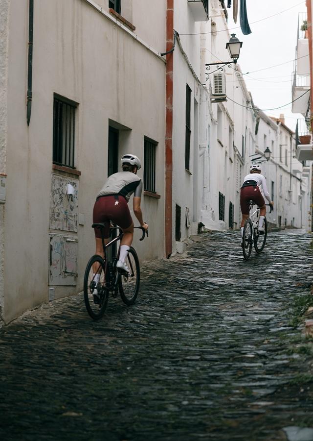 Kolarze podczas jazdy rowerem miejskimi ulIczkami 
