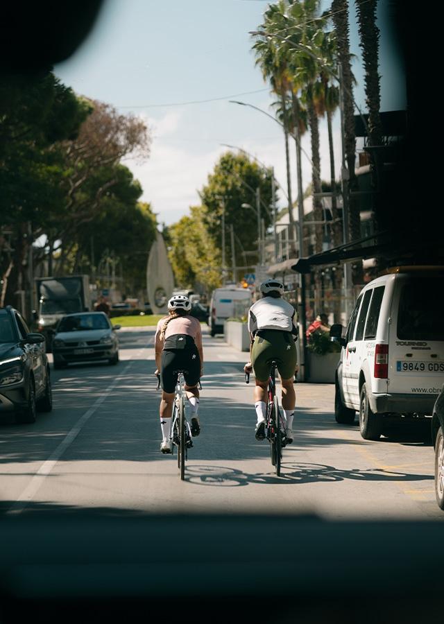 Kolarze podczas jazdy rowerem miejskimi ulIczkami 