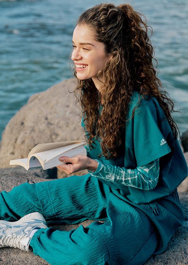 Kobieta w dresowym zestawie w modnym odcieniu głębokiej zieleni