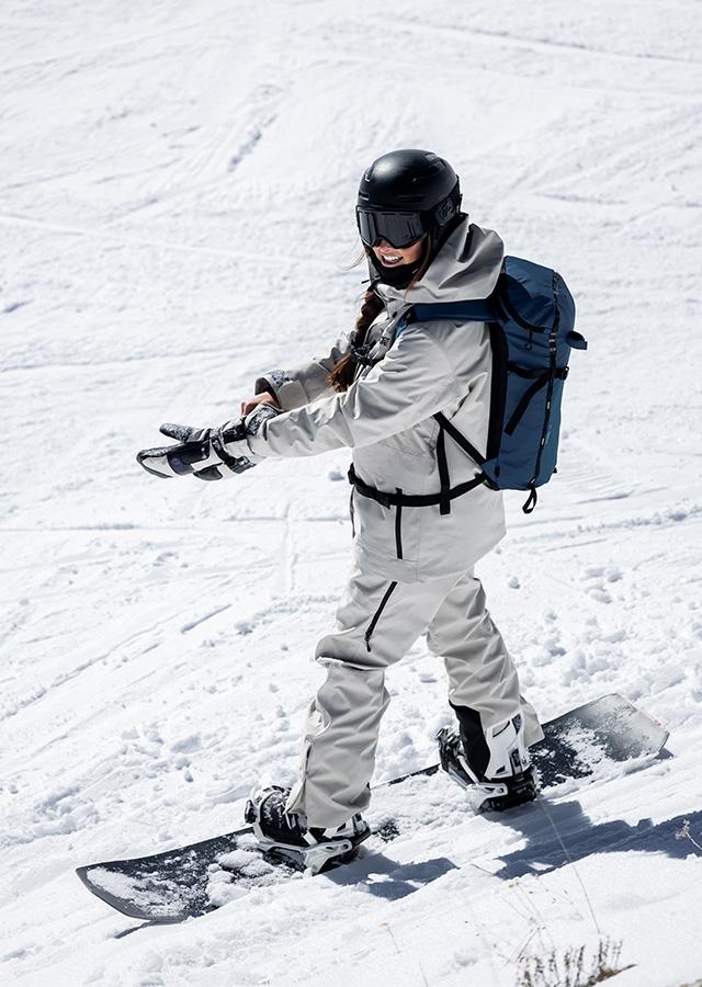 Kobieta podczas jazdy snowboardowej w czarnym kasku snowboardowym 