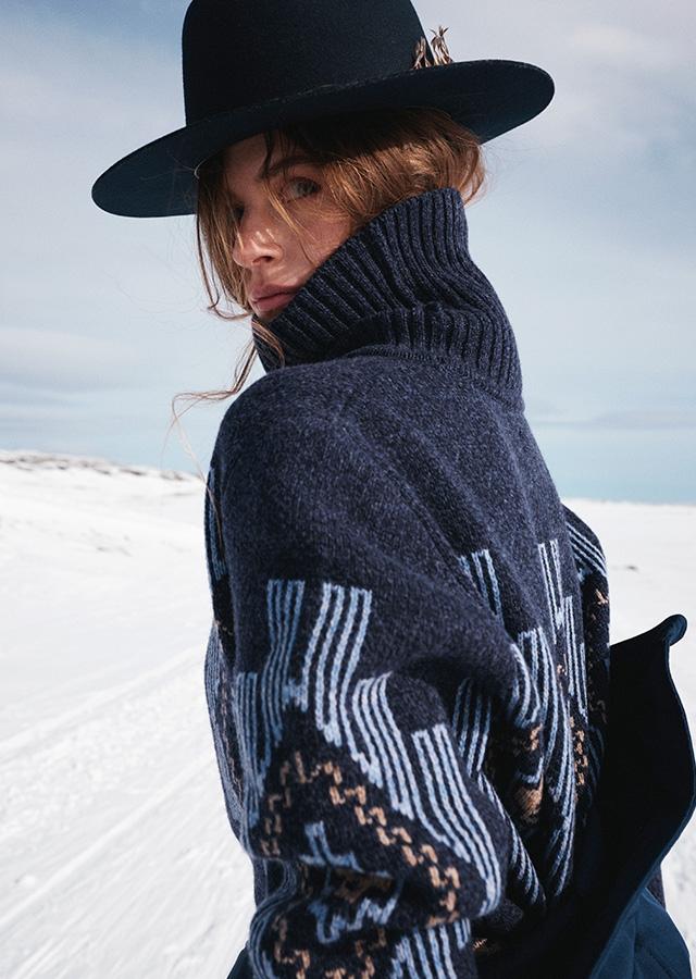 Kobieta w granatowym swetrze we wzory i czarnym kapeluszu    Kobieta w granatowym swetrze we wzory i czarnym kapeluszu