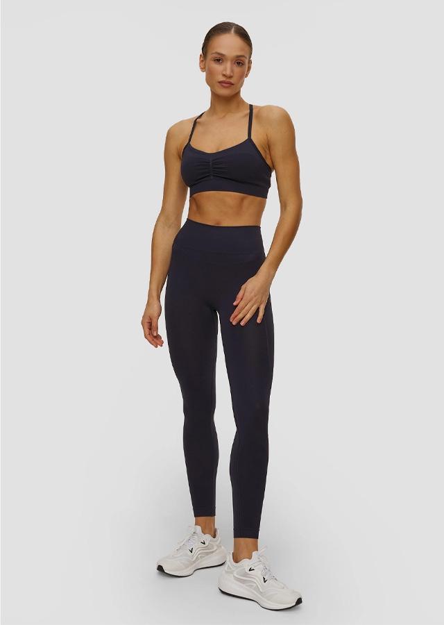 Kobieta w granatowych legginsach do jogi i topie od marki Adidas by Stella McCartney Kobieta w granatowych legginsach do jogi i topie od marki Adidas by Stella McCartney