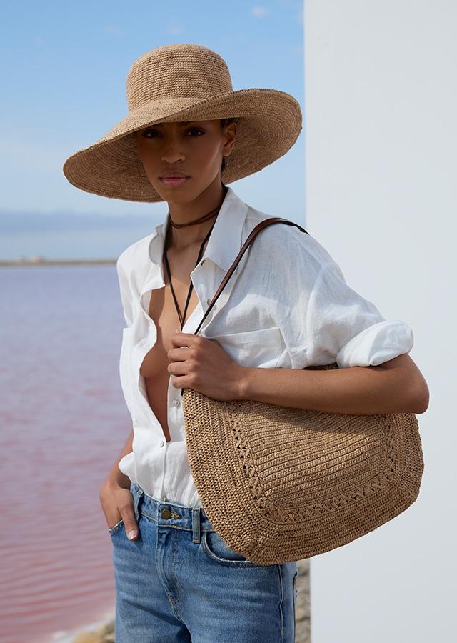 Kobieta w lnianej, białej koszuli i słomianym kapeluszu Kobieta w lnianej, białej koszuli i słomianym kapeluszu
