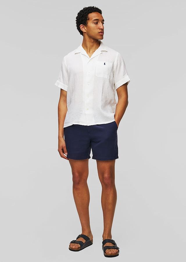 Muž v tmavomodrých ľanových šortkách a bielom tričku Muž v tmavomodrých ľanových šortkách a bielom tričku