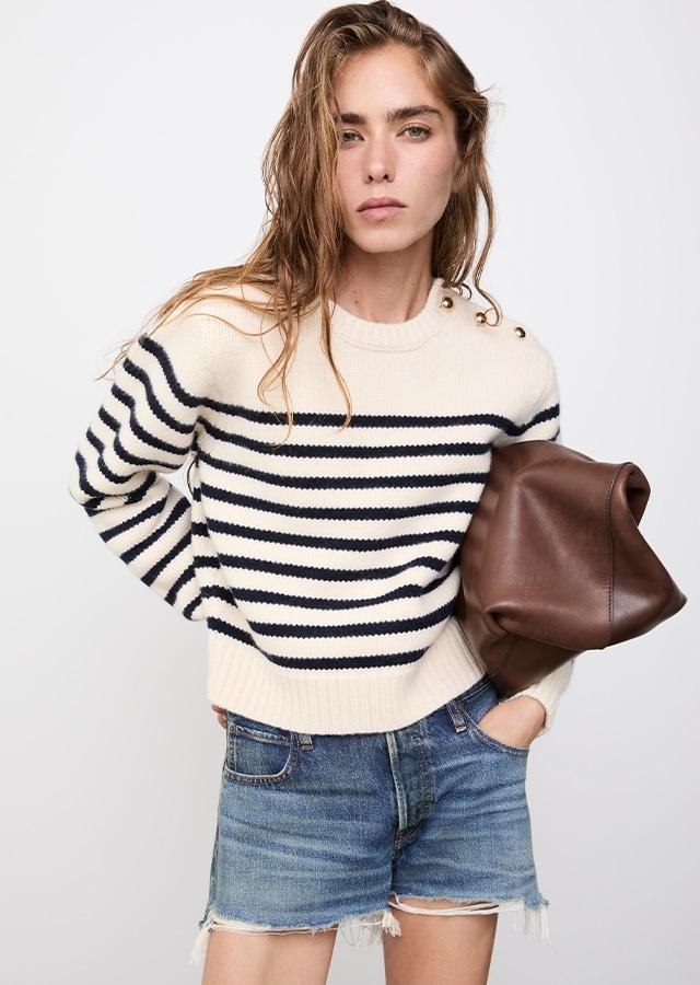 Kobieta w jeansowych szortach i sweterku w paski Kobieta w jeansowych szortach i sweterku w paski